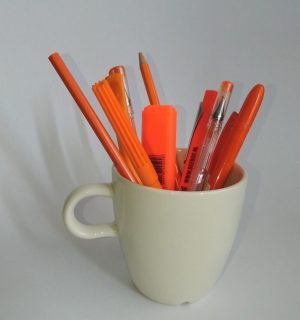 Beker met oranje pennen